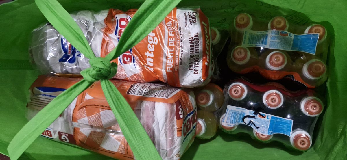 Despensa con pan, agua y bebidas lista para entrega en calle
