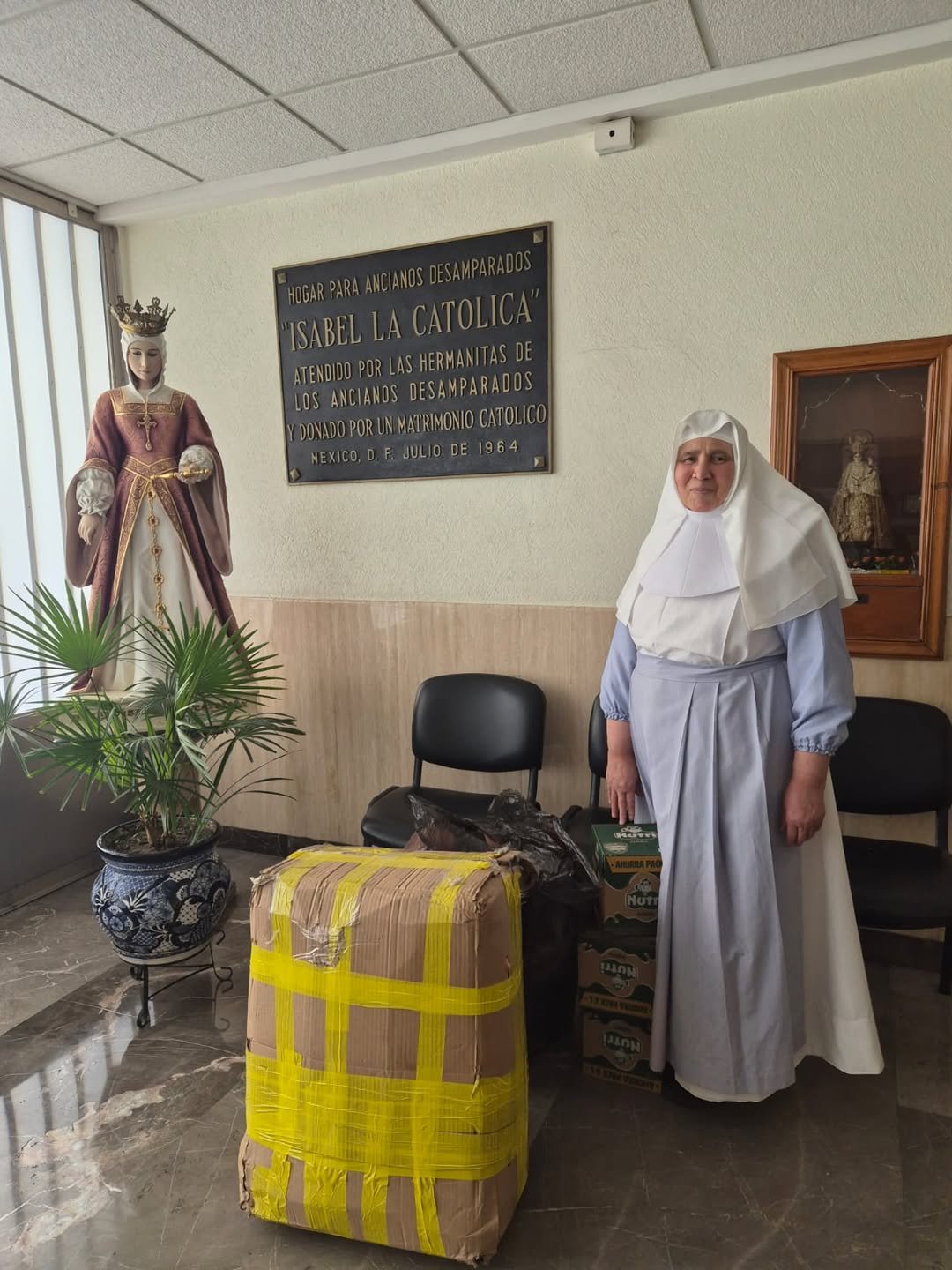 Hermanita del Hogar para Ancianos Desamparados Isabel la Católica junto a los donativos entregados